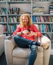 Casual man reading a book in a modern library setting